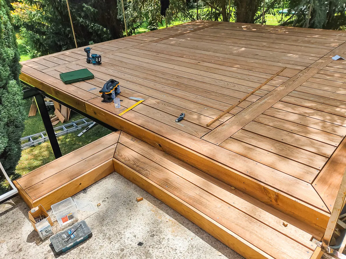 Photo d'une terrasse bois en construction, avec des outils éparpillés dessus