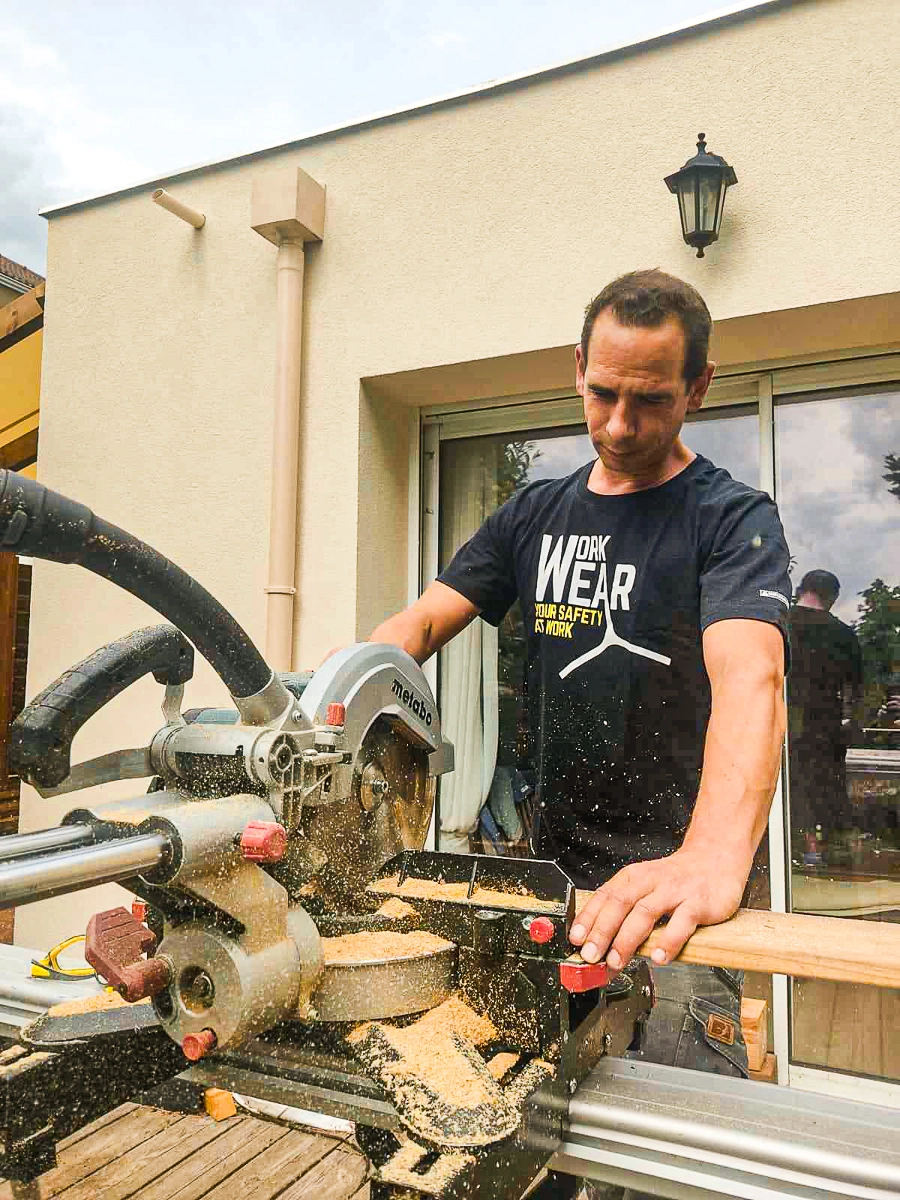 Portrait de Thibault Mamet, l'artisan derrière Woody Wood Concept, en train de scier une lame de bois